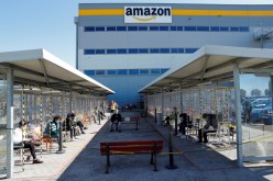 Workers relax during a break outside Amazon's distribution centre in Passo Corese, Italy