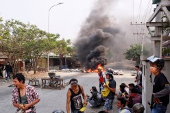 Demonstrators gather behind barricades during a protest against the military coup in Mandalay,