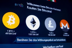 The exchange rates and logos of Bitcoin (BTH), Ether (ETH), Litecoin (LTC) and Monero (XMR) are seen on the display of a cryptocurrency ATM 