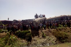 People inspect the damage after two trains have collided near the city of Sohag, Egypt,