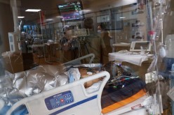 A coronavirus disease (COVID-19) positive patient lies in a bed in the intensive care unit (ICU) at Sarasota Memorial Hospital in Sarasota, Florida,