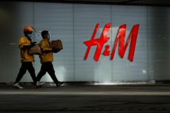 People walk past an H&M store in a shopping area in Beijing, China