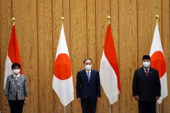 Japan's Prime Minister Yoshihide Suga poses with Indonesia's Foreign Minister Retno Marsudi and Defense Minister Prabowo Subianto