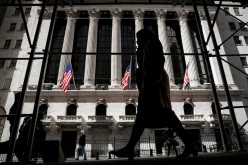 People are seen outside the New York Stock Exchange (NYSE) in New York City, U.S.,