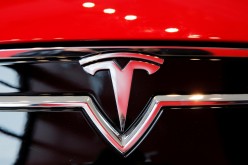 A Tesla logo on a Model S is photographed inside of a Tesla dealership in New York, U.S.,