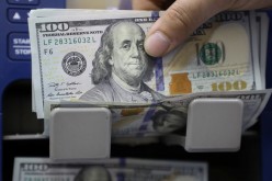 A man counts U.S. dollar banknotes at a currency exchange shop in Beirut, Lebanon