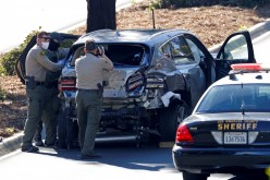 A sheriff officer takes photos of the damaged car of Tiger Woods following his car crash near Los Angeles, California, U.S., 