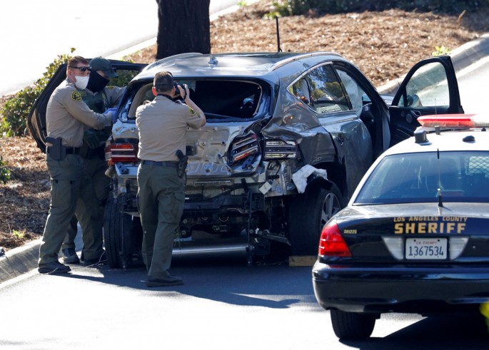 A sheriff officer takes photos of the damaged car of Tiger Woods following his car crash near Los Angeles, California, U.S., 