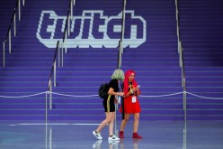 Attendees walk past a Twitch logo painted on stairs during opening day of E3, the annual video games expo revealing the latest in gaming software and hardware