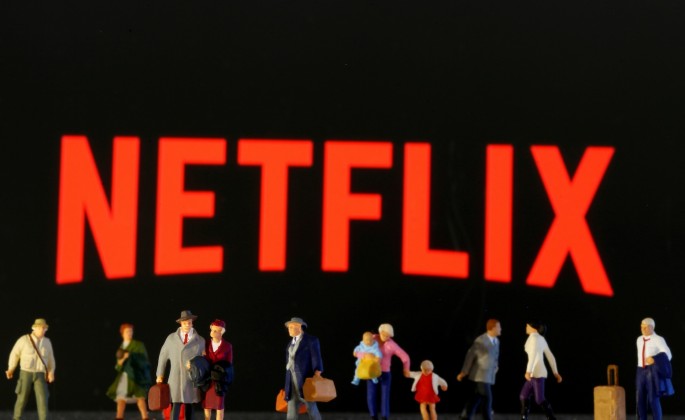 Small toy figures are seen in front of diplayed Netflix logo in this illustration taken 