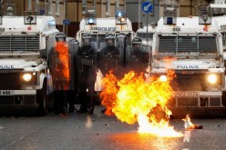 A fire burns in front of the police on the Springfield Road as protests continue in Belfast, Northern Ireland