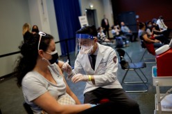 A woman receives a dose of the Johnson & Johnson coronavirus disease (COVID-19) vaccine during a visit of U.S. Vice President Kamala Harris to a vaccination center in Chinatown,