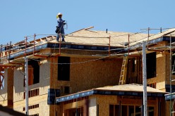 A worker walks on the roof of a new home under construction in Carlsbad, California