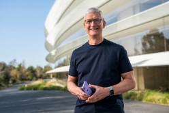 Apple CEO Tim Cook holds an iPhone 12 in a new purple finish, in this still image from the keynote video of a special event at Apple Park in Cupertino, California,