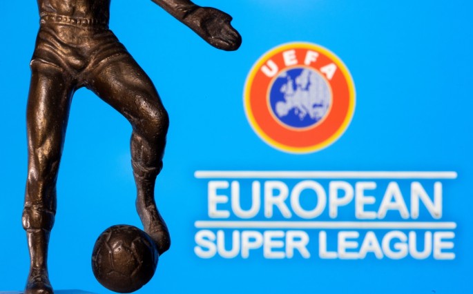 A metal figure of a football player with a ball is seen in front of the words "European Super League" and the UEFA logo in this illustration taken