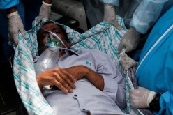 A patient suffering from the coronavirus disease (COVID-19) is evacuated from a hospital after it caught fire in Virar, on the outskirts of Mumbai, India,