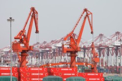 Canadian Tire containers are seen near cranes at Qingdao port in Shandong province, China, following an oil spill in the Yellow Sea caused by a collision 