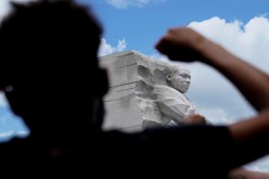 A demonstrator raises a fist in front of Martin Luther King Jr. Memorial during a protest to mark Juneteenth, which commemorates the end of slavery in Texas, 
