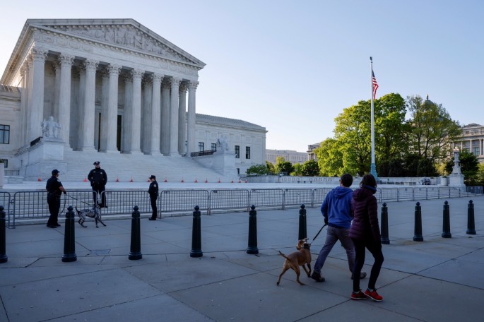 People walking a dog greet police officers and their dog outside the U.S. Supreme Court building in Washington, U.S