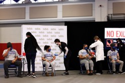 Students from Suffolk County Community College prepare to get vaccinated during a news conference on COVID-19 vaccination at Suffolk County Community College in Brentwood,