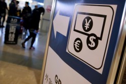 Currency signs of Japanese Yen, Euro and the U.S. dollar are seen on a board outside a currency exchange office at Narita International airport, near Tokyo