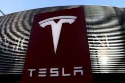 A logo of the electric vehicle maker Tesla is seen near a shopping complex in Beijing,