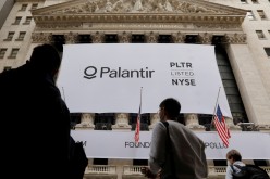  People walk by a banner featuring the logo of Palantir Technologies (PLTR) at the New York Stock Exchange (NYSE) on the day of their initial public offering (IPO) in Manhattan,