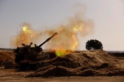 An Israeli mobile artillery unit fires near the border between Israel and the Gaza Strip,