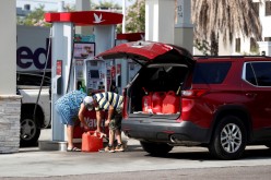 A couple fills up multiple 5 gallon gas tanks at a Wawa gas station, after a cyberattack crippled the biggest fuel pipeline in the country, run by Colonial Pipeline