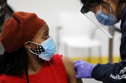 A woman is bandaged after her inoculation by a health worker from Humber River Hospital during a vaccination clinic for residents 18 years of age and older who live in coronavirus disease