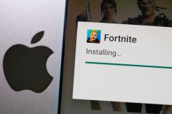 Fortnite game installing on Android operating system is seen in front of Apple logo in this illustration taken,