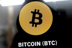 A Bitcoin (BTC) logo is displayed on a crypto currency ATM machine in a shop in Weehawken, New Jersey, U.S.,
