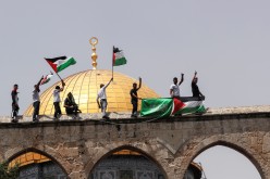 Palestinians hold flags as they stand at the compound that houses Al-Aqsa Mosque, known to Muslims as Noble Sanctuary and to Jews as Temple Mount, 