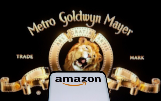 Smartphone with Amazon logo is seen in front of displayed MGM logo in this illustration