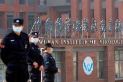 Security personnel keep watch outside the Wuhan Institute of Virology during the visit by the World Health Organization (WHO) team
