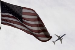 A Delta Airlines flight takes off past a U.S. flag in Boston, Massachusetts, U.S