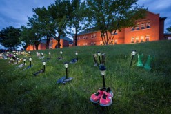 Pairs of children's shoes and toys are seen at memorial in front of the former Kamloops Indian Residential School