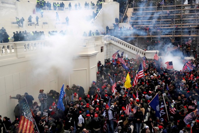  Police release tear gas into a crowd of pro-Trump protesters during clashes at a rally to contest the certification of the 2020 U.S. presidential election results