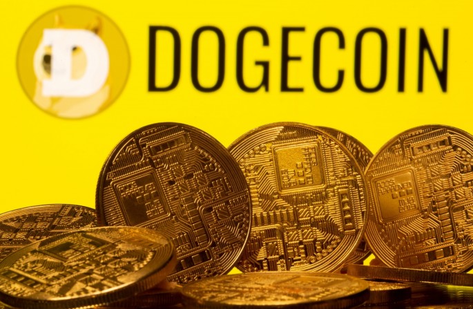 Cryptocurrency representations are seen in front of the Dogecoin logo in this illustration picture taken