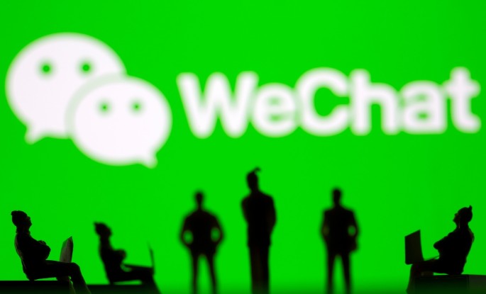 Small toy figures are seen in front of WeChat logo in this illustration picture taken