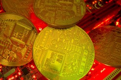 Representations of the virtual currency stand on a motherboard in this picture illustration taken