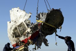 Local workers transport a piece of the Malaysia Airlines flight MH17 wreckage at the site of the plane crash near the village of Hrabove (Grabovo)