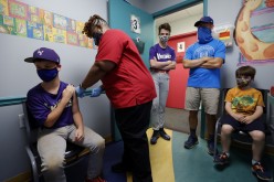 Family members look on as Jack Frilingos, 12, is inoculated with Pfizer's vaccine against coronavirus disease (COVID-19)