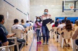 Single mother Lizbeth Leon Adame, from Mexico, walks with her daughter Lizbetha after getting a COVID-19 vaccine at a clinic planned for and organized