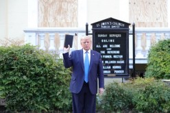 U.S. President Donald Trump holds up a Bible as he stands in front of St. John's Episcopal Church across from the White House after walking there