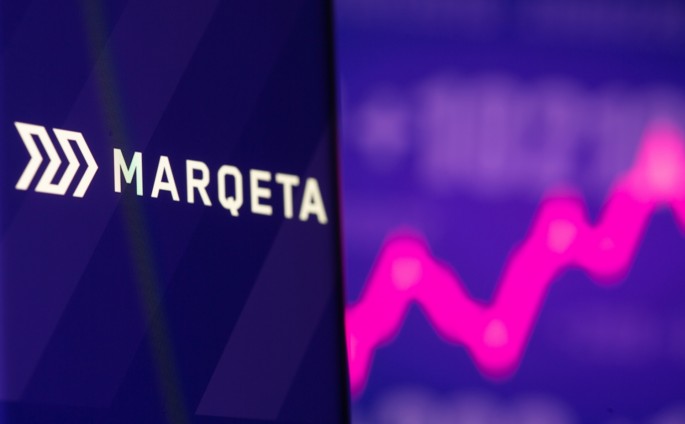 Marqeta logo is seen on a smartphone in front of displayed stock graph in this illustration picture taken