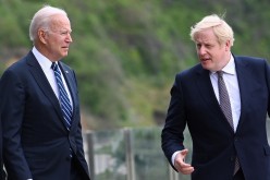 Britain's Prime Minister Boris Johnson speaks with U.S. President Joe Biden while they walk outside Carbis Bay Hotel, Carbis Bay