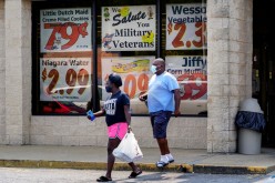 Shoppers leave a Piggly Wiggly supermarket with a sign honoring veterans in its window in Columbus, Georgia, U.S.