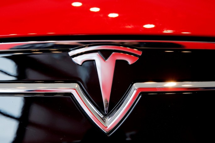 A Tesla logo on a Model S is photographed inside of a Tesla dealership in New York, U.S.,