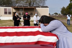Lila Blanks holds the casket of her husband, Gregory Blanks, 50, who died of the coronavirus disease (COVID-19),